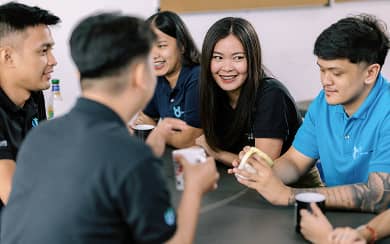 Beyond Limits team members having a casual discussion during a break at the Clarkfield, Philippines office.